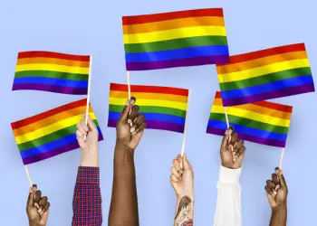 Hands waving rainbow flags