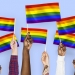 Hands waving rainbow flags