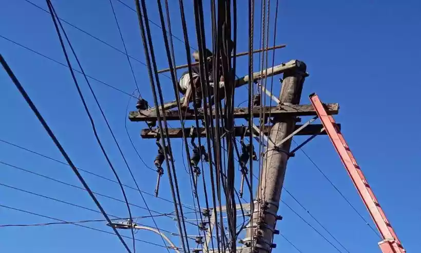 homem em cima de um poste em mg