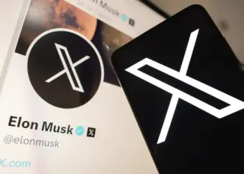 Nesta foto ilustração, o Twitter (X) novo logotipo visto exibido em um smartphone. Em segundo plano, o perfil oficial de Elon Musk, novo proprietário da rede social Twitter